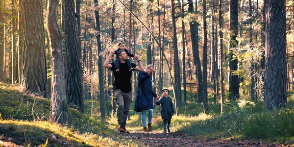 Family walking through a forest with their dog — vh1be lifestyle inspired by nature, balance, and wellness